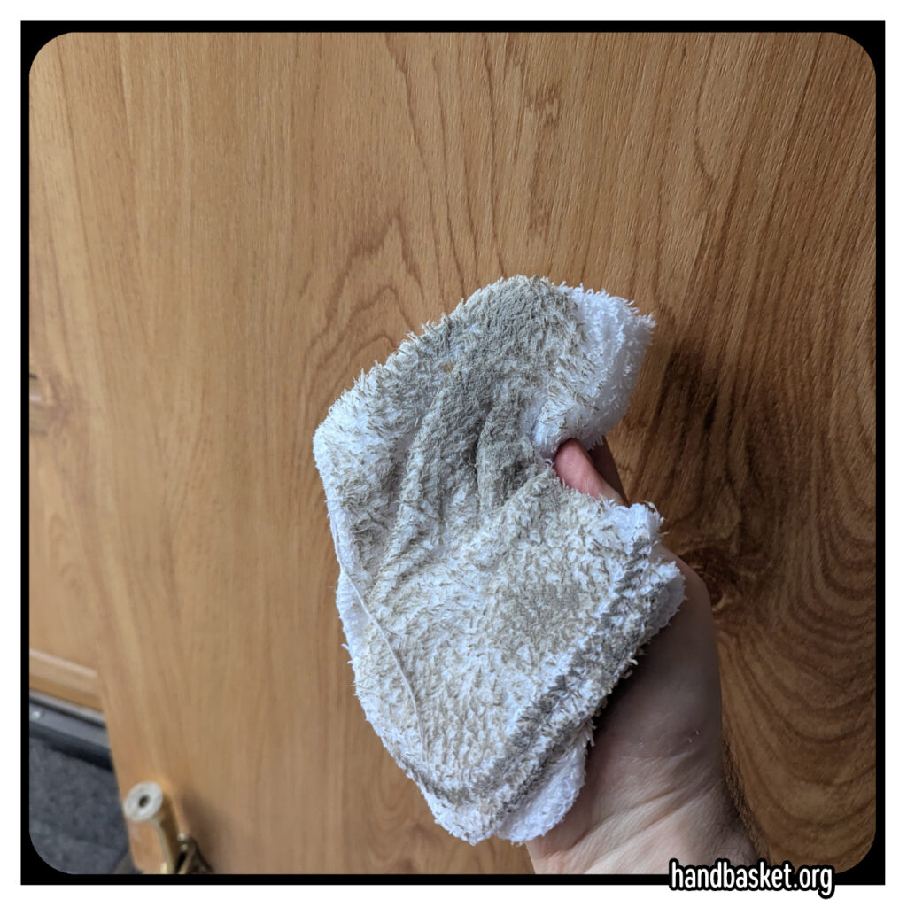 my hand holding up a filthy washrag
